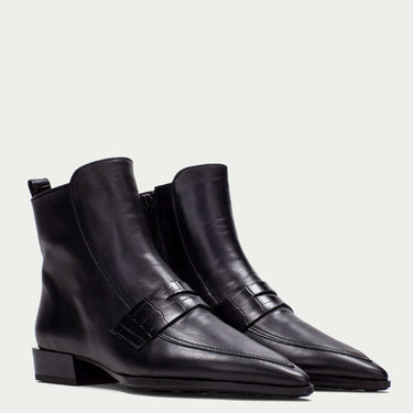 Pair of black leather ankle boots on a light gray background