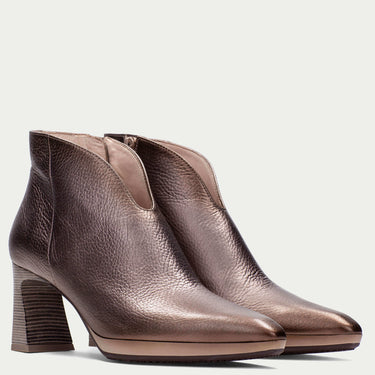 Pair of bronze ankle boots on a light gray background