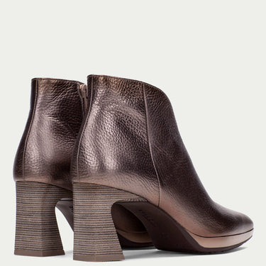 Pair of bronze metallic leather ankle boots with block heels on a light gray background