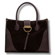 A dark brown handbag with a mix of suede and textured leather panels, featuring dual top handles, a front strap closure with a leather tassel, and a gold-tone metal D-ring and brand plaque.