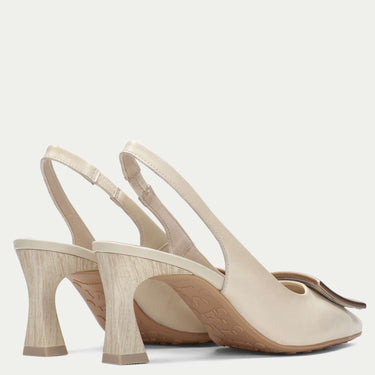 Pair of beige high-heeled shoes on a light gray background