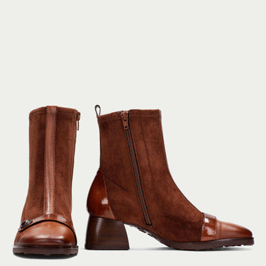 Pair of brown leather boots on a light beige background