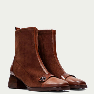 Pair of brown leather boots on a light gray background