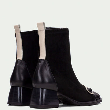 Black ankle boots with beige accents on a light gray background