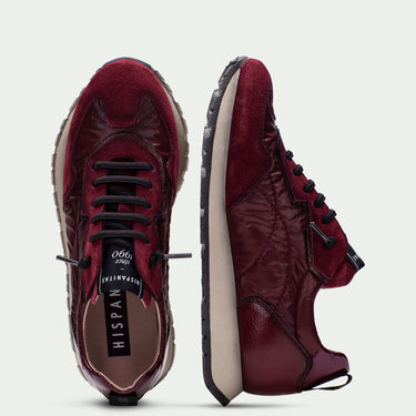 Maroon sneakers with black laces on a light gray background
