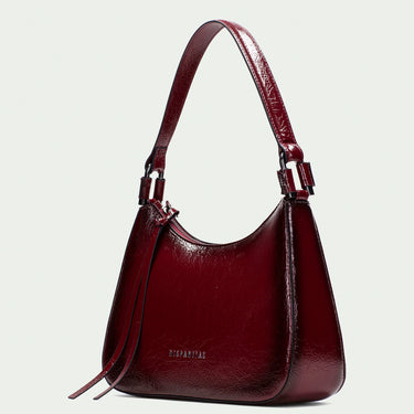 Burgundy handbag with a strap on a light gray background