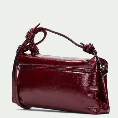 Burgundy handbag with decorative handle on a light gray background