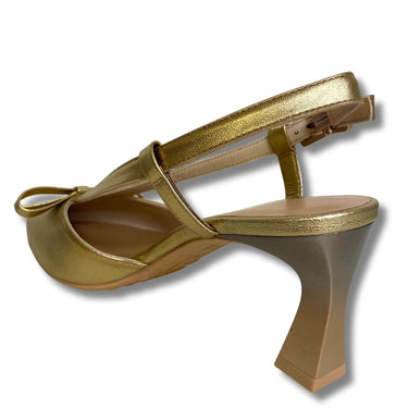Gold high-heeled shoe with a bow on a white background