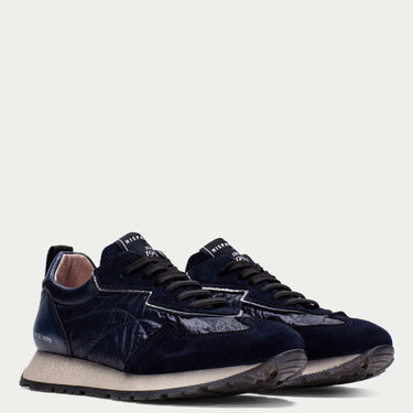 Pair of navy blue sneakers on a light gray background