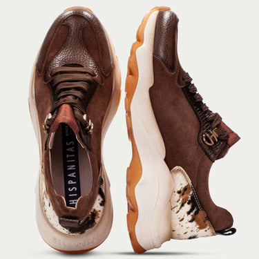 Pair of brown and white sneakers with visible brand name on a light gray background