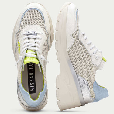 Pair of white sneakers with green accents on a light gray background