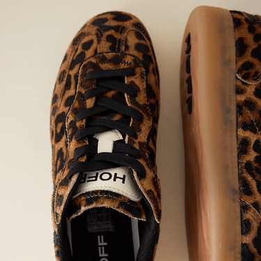 Leopard print sneakers with black laces on a beige background