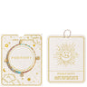 A Joma Jewellery affirmation card set featuring a gold and turquoise beaded bracelet on a textured cream card with gold celestial illustrations, shown alongside its matching branded backing card and hanging tag.