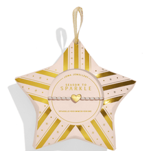 Star-shaped jewelry box with gold stripes and 'Season to Sparkle' text on a white background