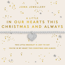 Joma Jewellery Christmas-themed bracelet on a cream card. The bracelet features a silver-toned band with a central heart-shaped crystal charm.