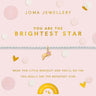 A delicate silver bracelet with a gold crescent moon and star charm, presented on a light pink Joma Jewellery gift card with gold lettering and decorative dots.