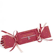 Red Christmas cracker with ribbons and a heart-shaped charm on a white background