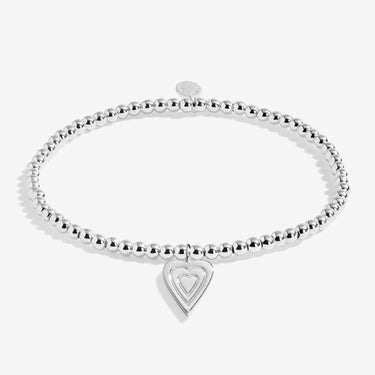 Silver bracelet with a heart-shaped charm on a white background