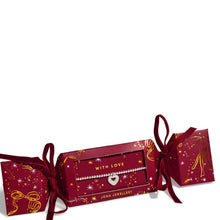 A Johnnie Jewellery bracelet presented in a red Christmas-themed pull-box gift packaging with gold star and ribbon illustrations, on a plain white background.