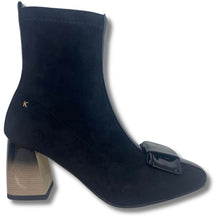 A black suede ankle boot with a glossy black patent leather block heel and a matching glossy black square buckle detail on the toe, shown against a plain white background.
