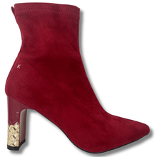 Red suede ankle boot with gold heel on a white background