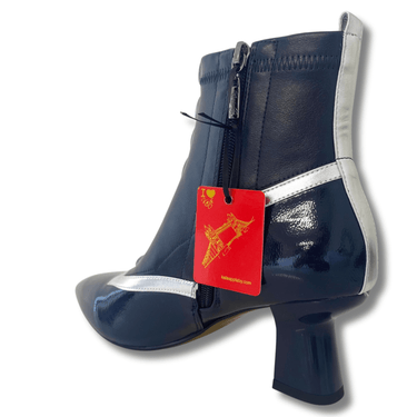 Navy blue ankle boot with silver trim and a red tag on a white background