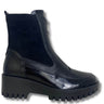 A black ankle boot with a glossy patent leather toe, a matte black leather side panel, a black suede-like upper, and a chunky black lug sole, shown against a plain white background.