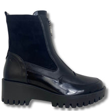 A black ankle boot with a glossy patent leather toe, a matte black leather side panel, a black suede-like upper, and a chunky black lug sole, shown against a plain white background.
