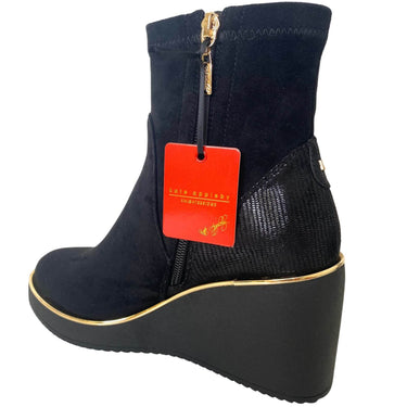 Black wedge heel boot with a red tag on a white background