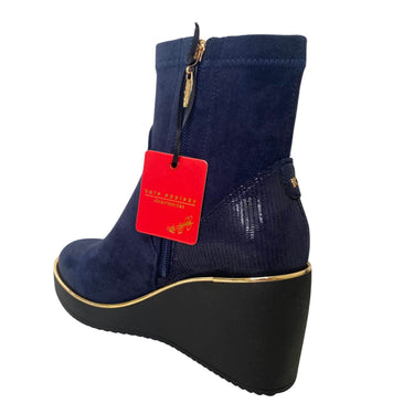 Navy wedge boot with a red tag on a white background