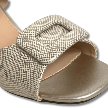 Beige sandal with textured strap on a white background