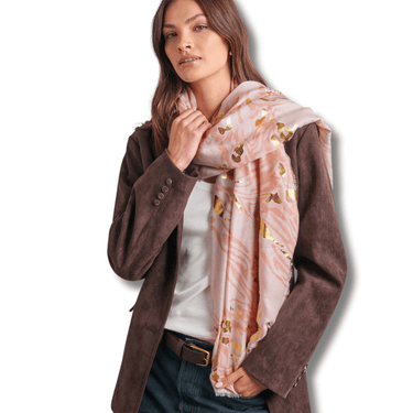 Woman wearing a brown coat and a patterned scarf on a white background