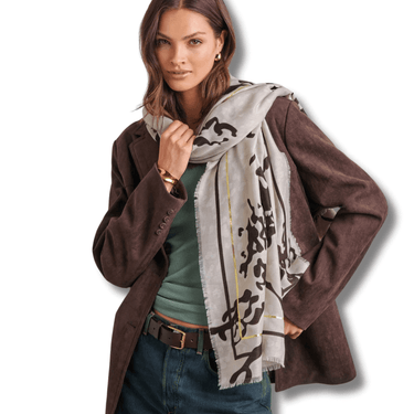 Woman wearing a brown coat and patterned scarf on a white background