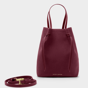 Maroon handbag with a strap on a light gray background