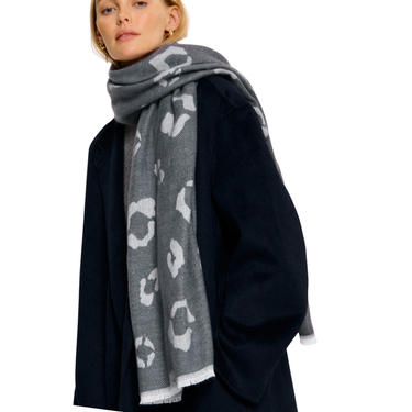 Person wearing a gray scarf with white patterns on a white background