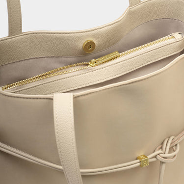 Beige handbag with gold zipper and strap details on a light gray background
