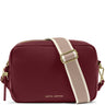 A Katie Loxton burgundy pebbled leather camera bag with a beige and white striped webbing strap and gold-tone hardware, shown on a white background.