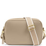 A Katie Loxton crossbody bag in beige pebbled leather with a wide beige and white striped webbing strap and gold-tone hardware, shown on a plain white background.
