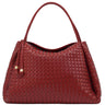 A red woven leather handbag with a single top handle and a small leather tassel detail, shown against a plain white background.