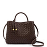 A dark brown woven leather handbag with braided top handles and a detachable shoulder strap, featuring two small gold-tone hardware accents on the front, set against a plain white background.