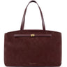A dark burgundy suede tote bag with matching leather handles and a small gold-tone logo plate on the front, photographed against a solid white background.