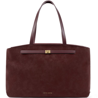 A dark burgundy suede tote bag with matching leather handles and a small gold-tone logo plate on the front, photographed against a solid white background.
