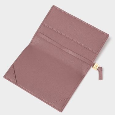 Pink leather passport cover with a gold zipper on a light gray background