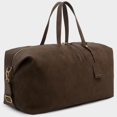 Brown suede duffel bag with gold accents on a light gray background