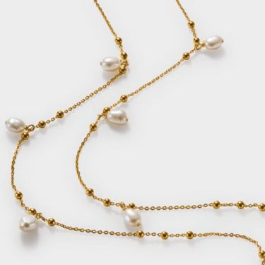 Gold chain necklace with pearls on a white background