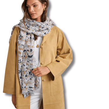 Woman wearing a tan coat and floral scarf on a white background