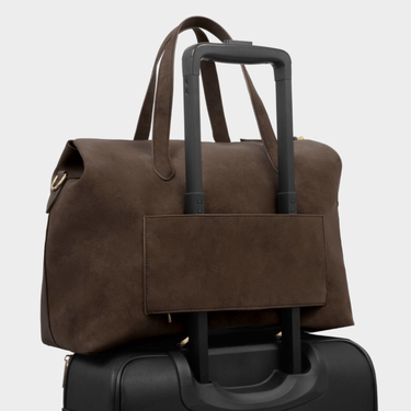 Brown leather duffel bag with handle and wheels on a light gray background