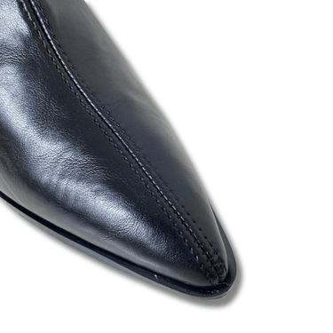 Close-up of a black leather shoe with a pointed toe on a white background