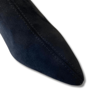 Close-up of a black pointed-toe shoe on a white background