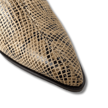 Close-up of a pointed-toe shoe with textured pattern on a white background